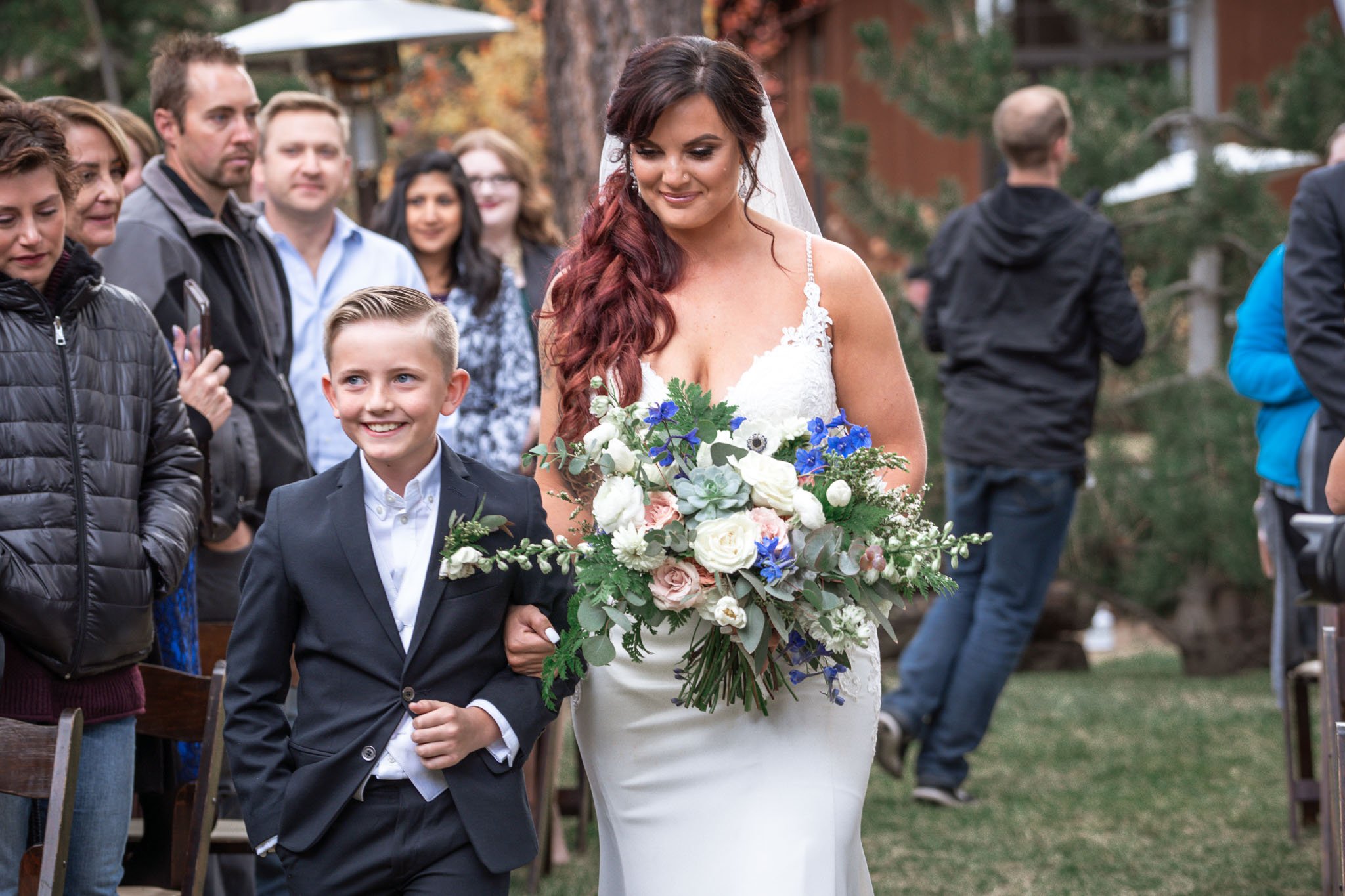 Black Bear Lodge Wedding | Jackie + Rick Bride walking down the aisle holding hands with her young son