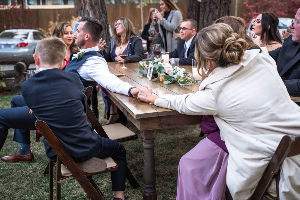 Lake Tahoe Wedding Photography Bridesmaid and her husband holding hands across a table