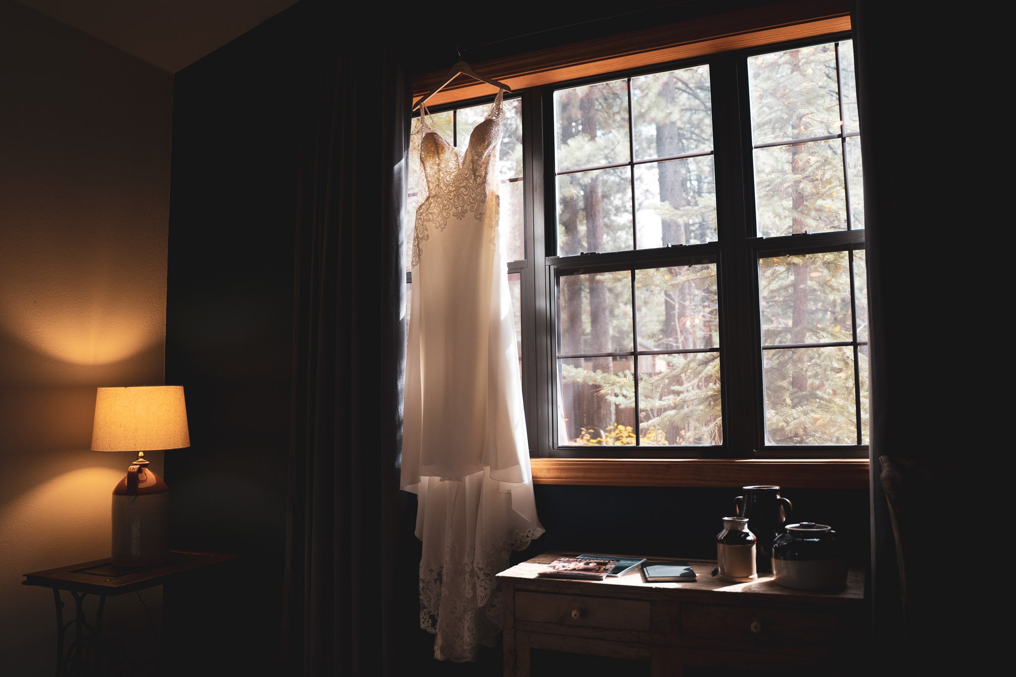 Black Bear Lodge Wedding | Jackie + Rick Wedding dress hanging from a window
