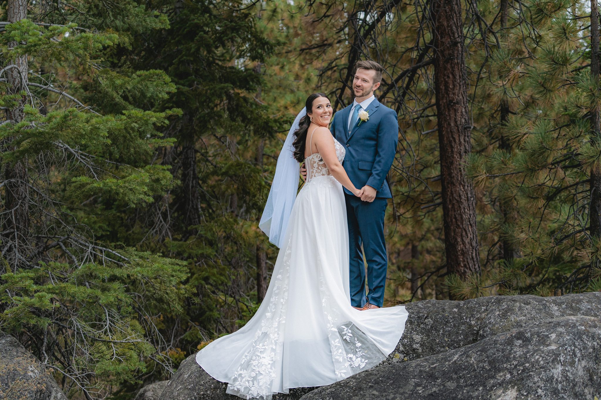 bride and groom standing together on a scenic forest overlook, capturing a joyful wedding day moment and showing how to enjoy wedding photos naturally and confidently