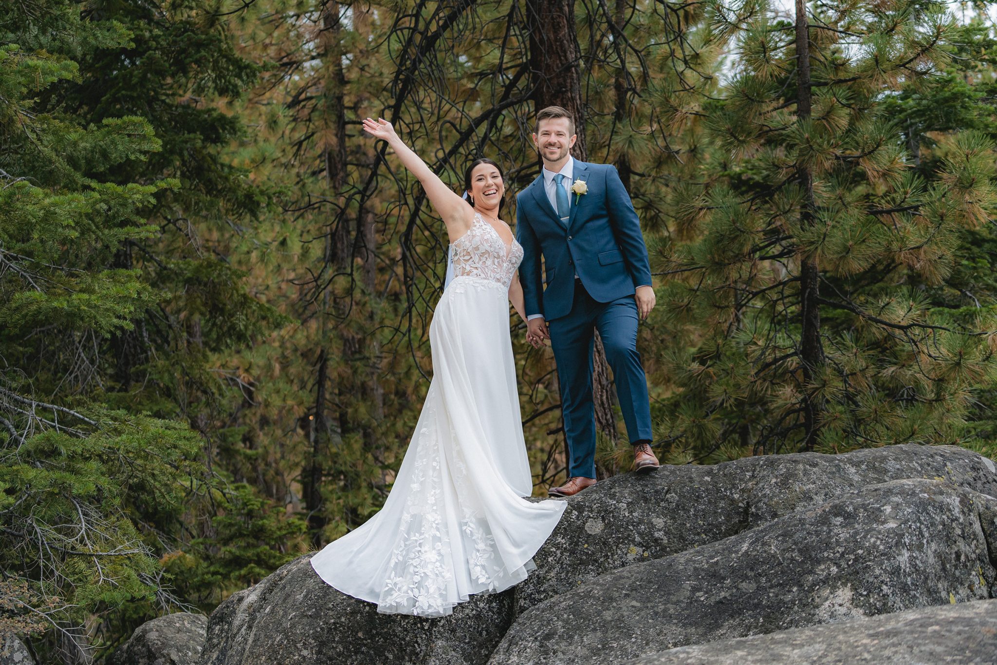 bride and groom celebrating together on a rocky forest overlook, showcasing natural couple portraits and a comfortable wedding photography experience in Lake Tahoe