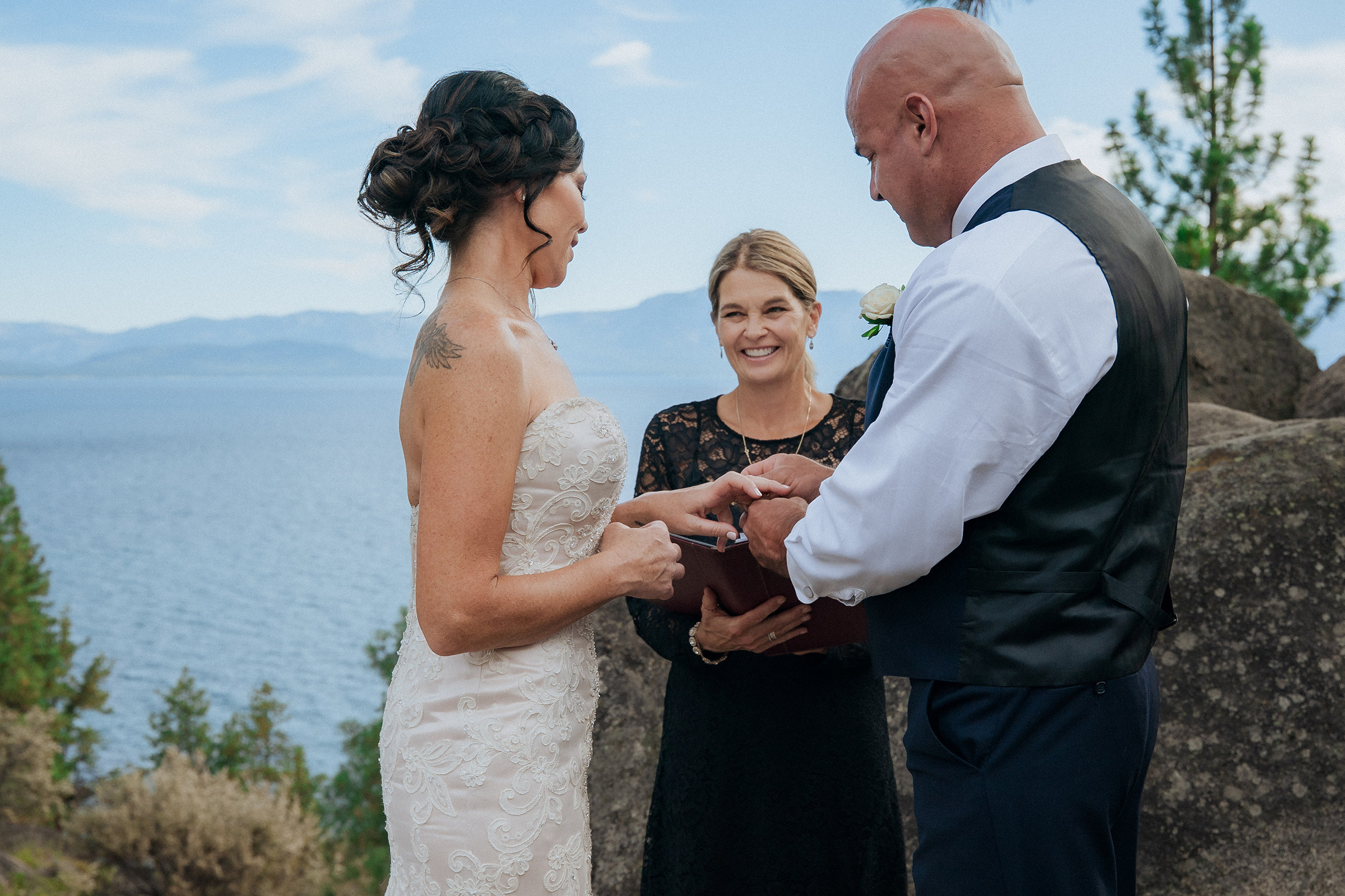 Logan Shoals outdoor wedding ceremony with a bride and groom exchanging vows with an officiant overlooking Lake Tahoe and scenic mountain views.