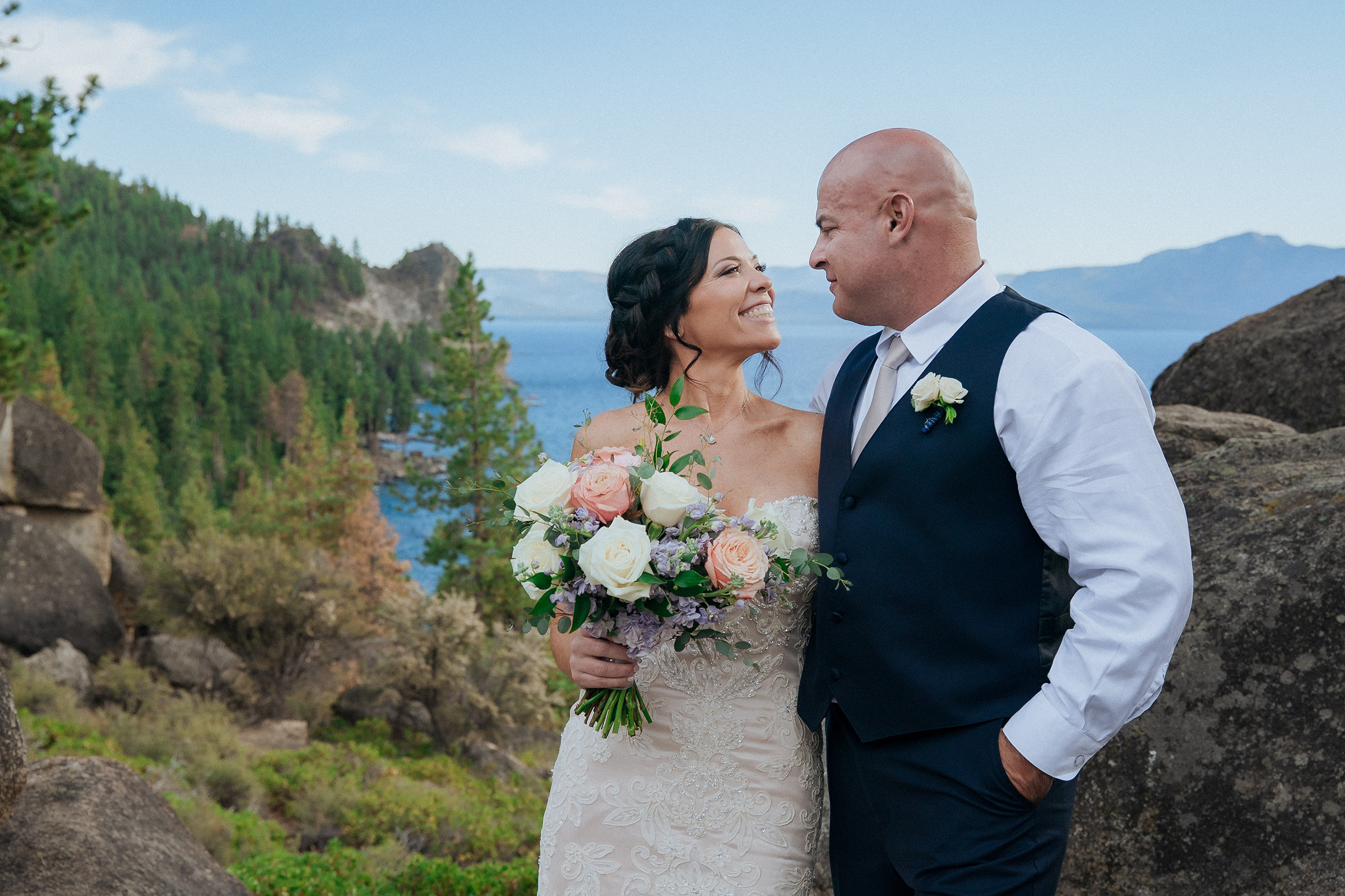 Logan Shoals wedding photographer capturing a newlywed couple with a bouquet overlooking Lake Tahoe and scenic mountain views.
